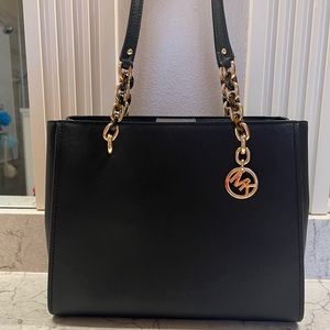 Michael Kors black handbag with internal center zipper section.